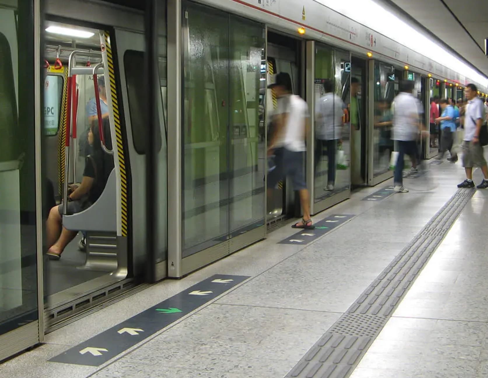 Fahrgäste steigen hinter Bahnsteigtüren von Gilgen in eine U-Bahn ein